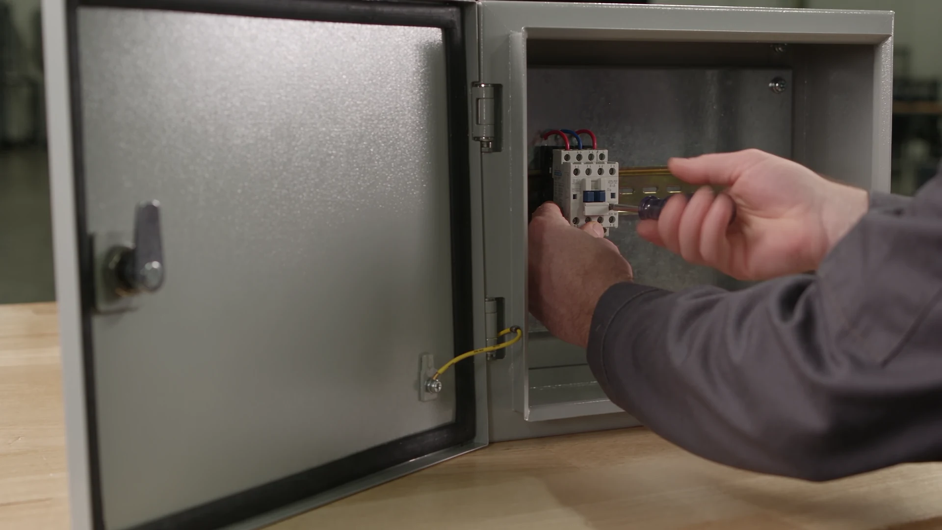 A technician fastening a rail inside a generic enclosure.